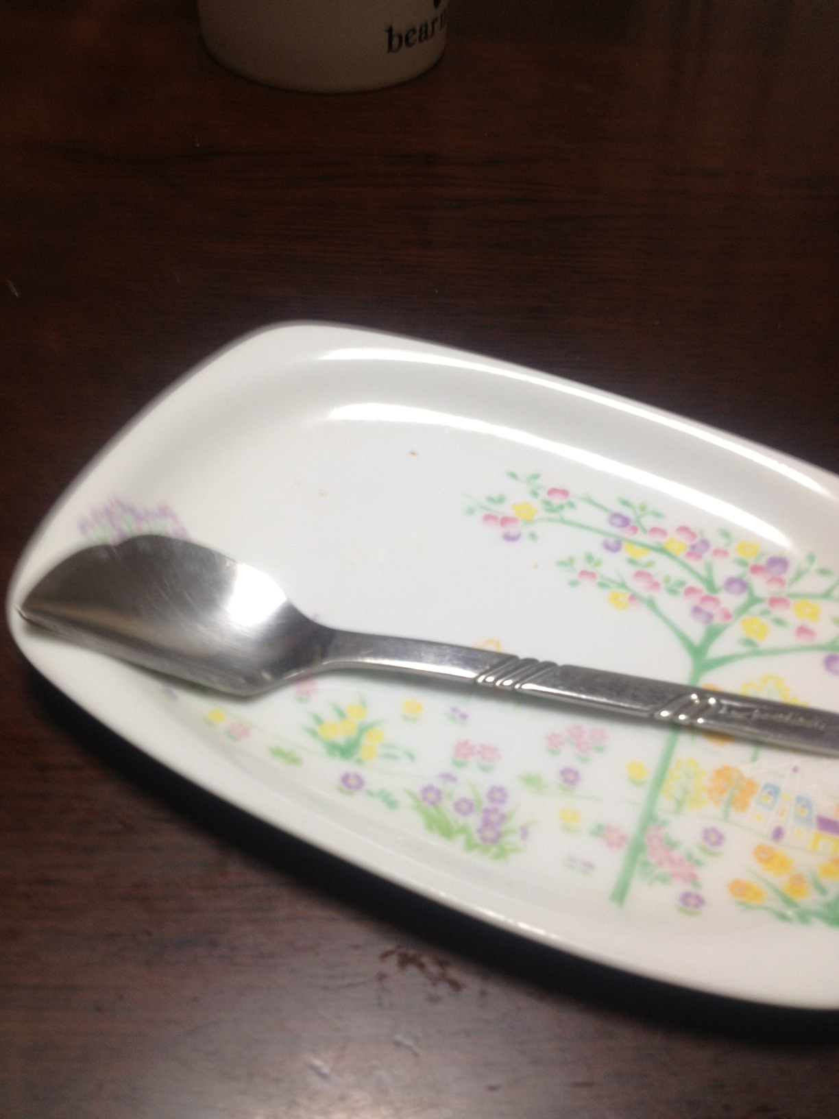A photo captured by a person who is blind. A computer-generated caption for this photo is: A spoon and a fork on a plate.