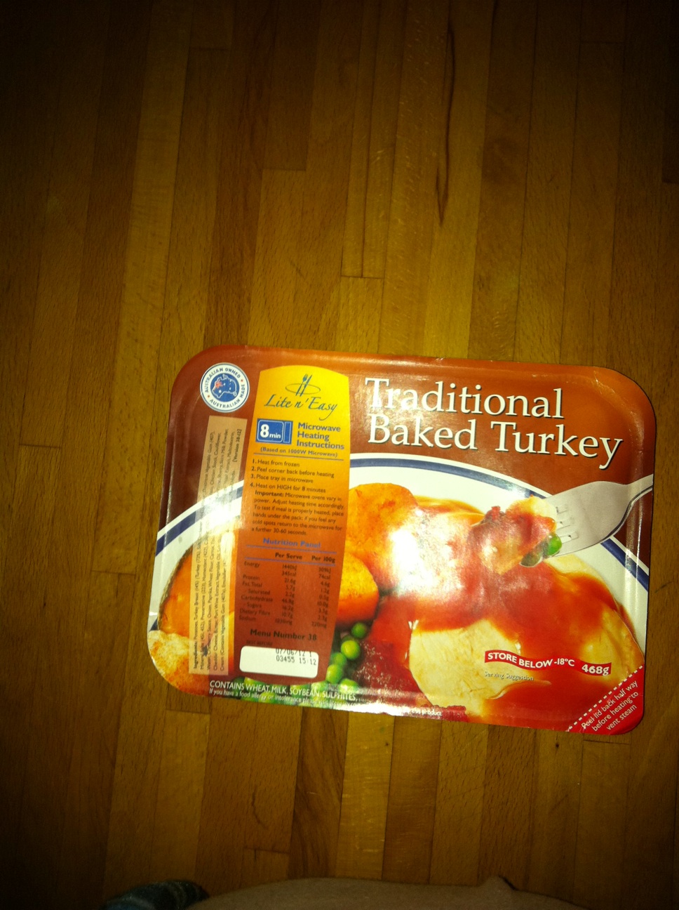 A photo captured by a person who is blind. A computer-generated caption for this photo is: A box of food is on a wooden table.