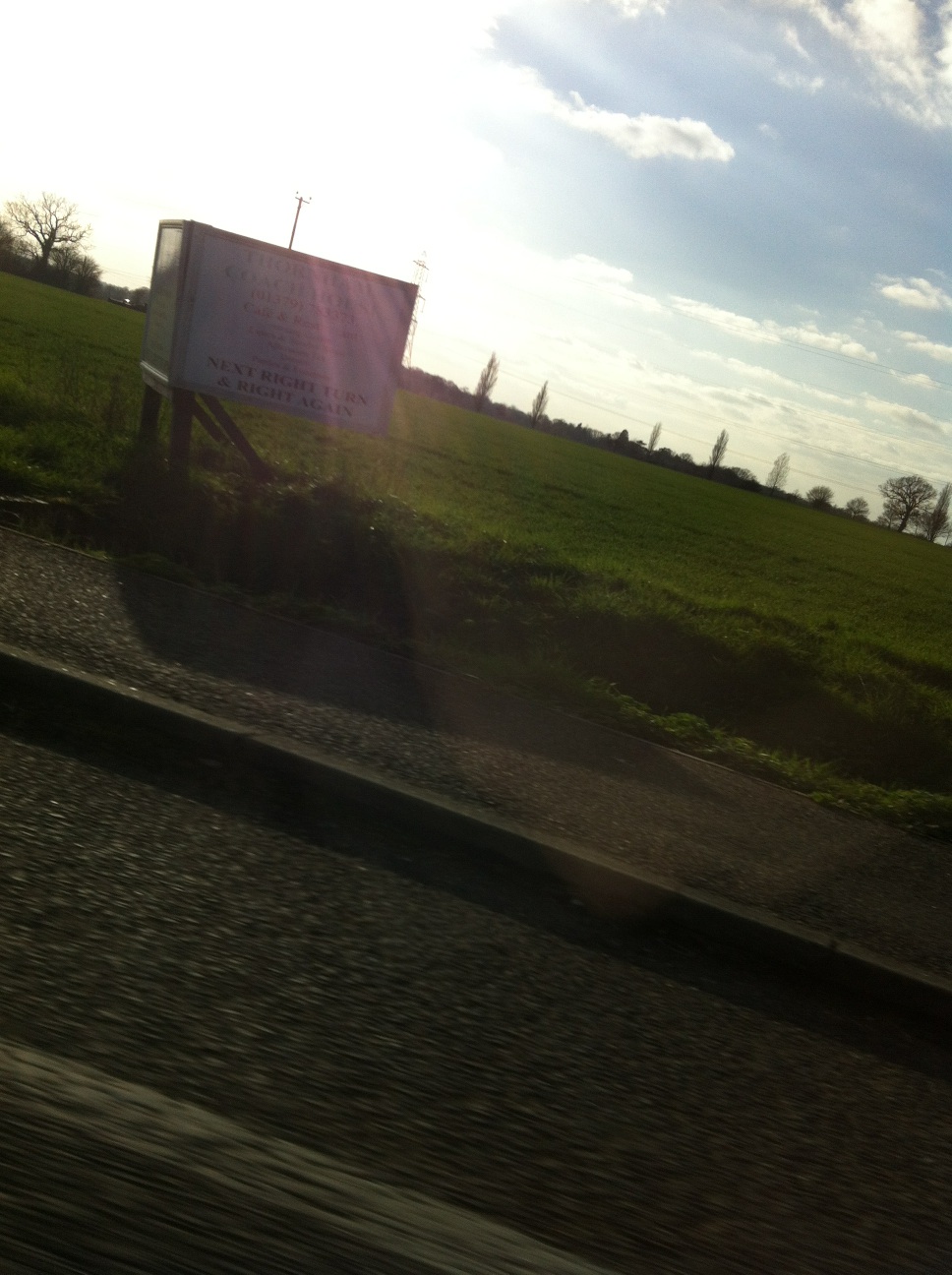 A photo captured by a person who is blind. A computer-generated caption for this photo is: There is a sign on the side of the road.