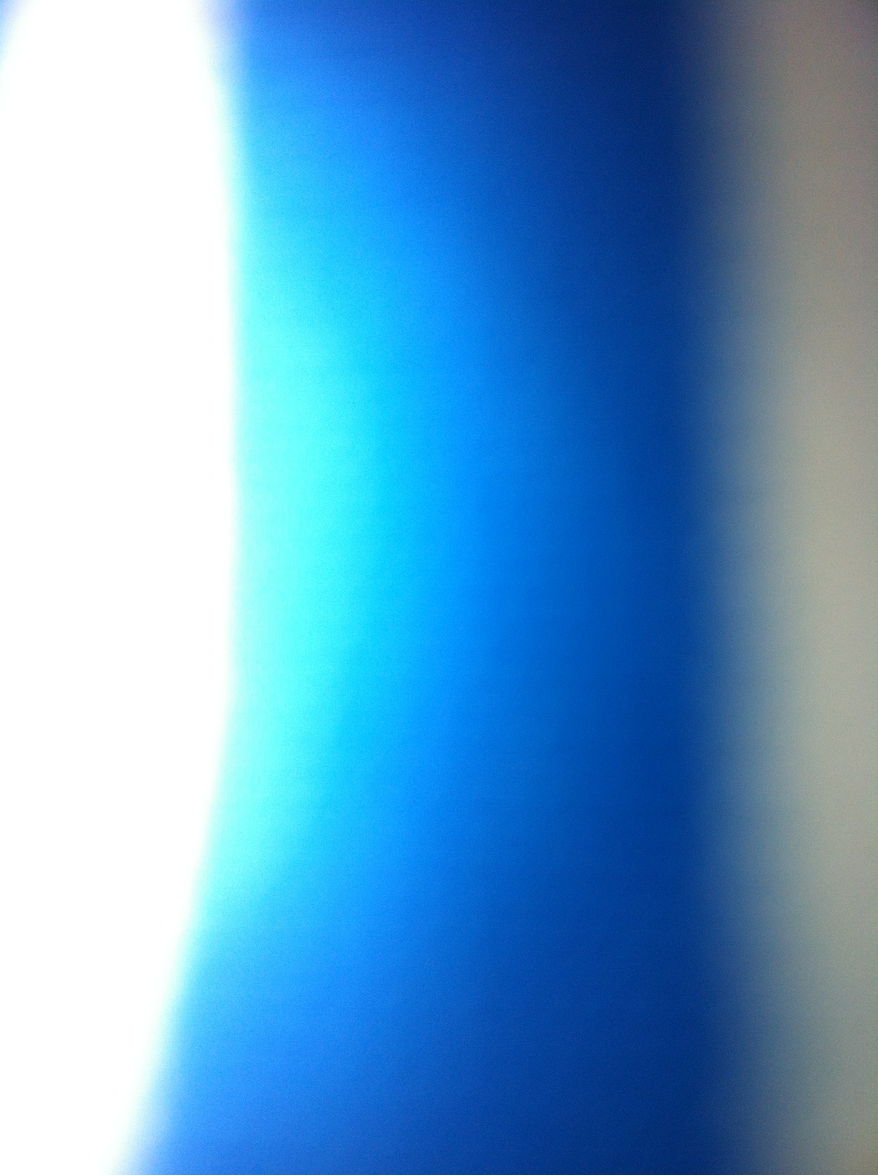 A photo captured by a person who is blind. A computer-generated caption for this photo is: A close up of a blue sky with a light.