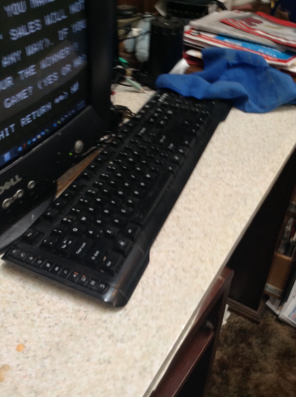 A photo captured by a person who is blind. A computer-generated caption for this photo is: A black keyboard sitting on top of a counter.