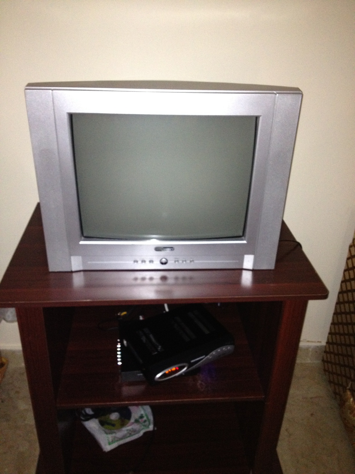 A photo captured by a person who is blind. A computer-generated caption for this photo is: A television sitting on top of a wooden table.