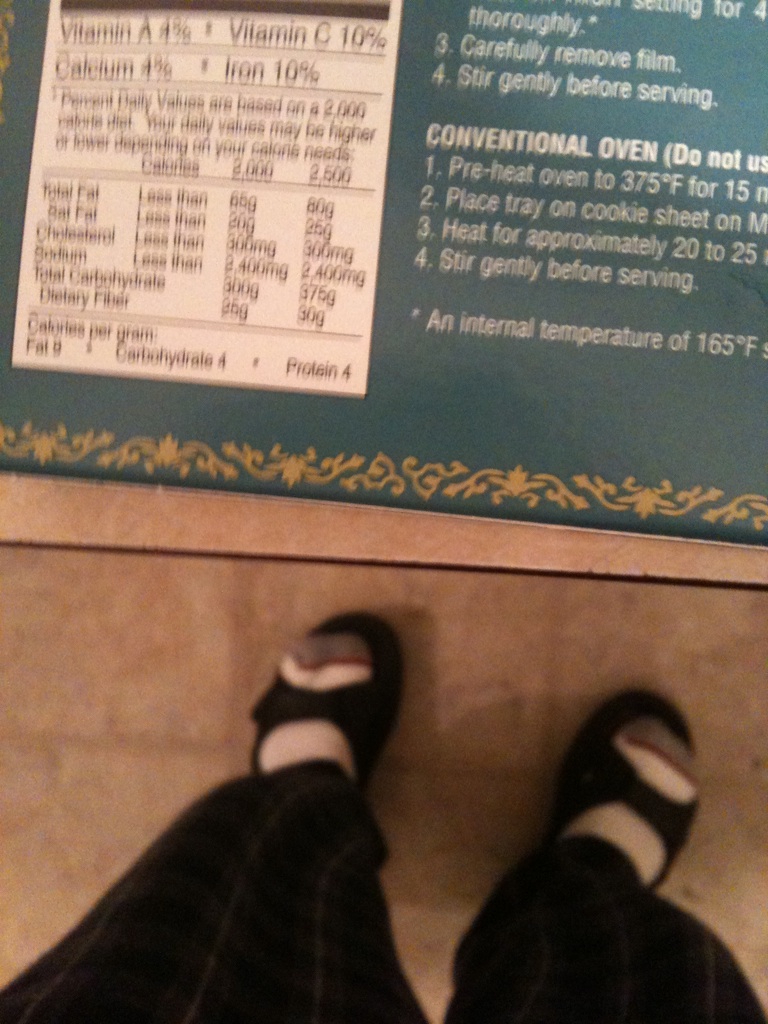 A photo captured by a person who is blind. A computer-generated caption for this photo is: A person ' s feet in front of a book.