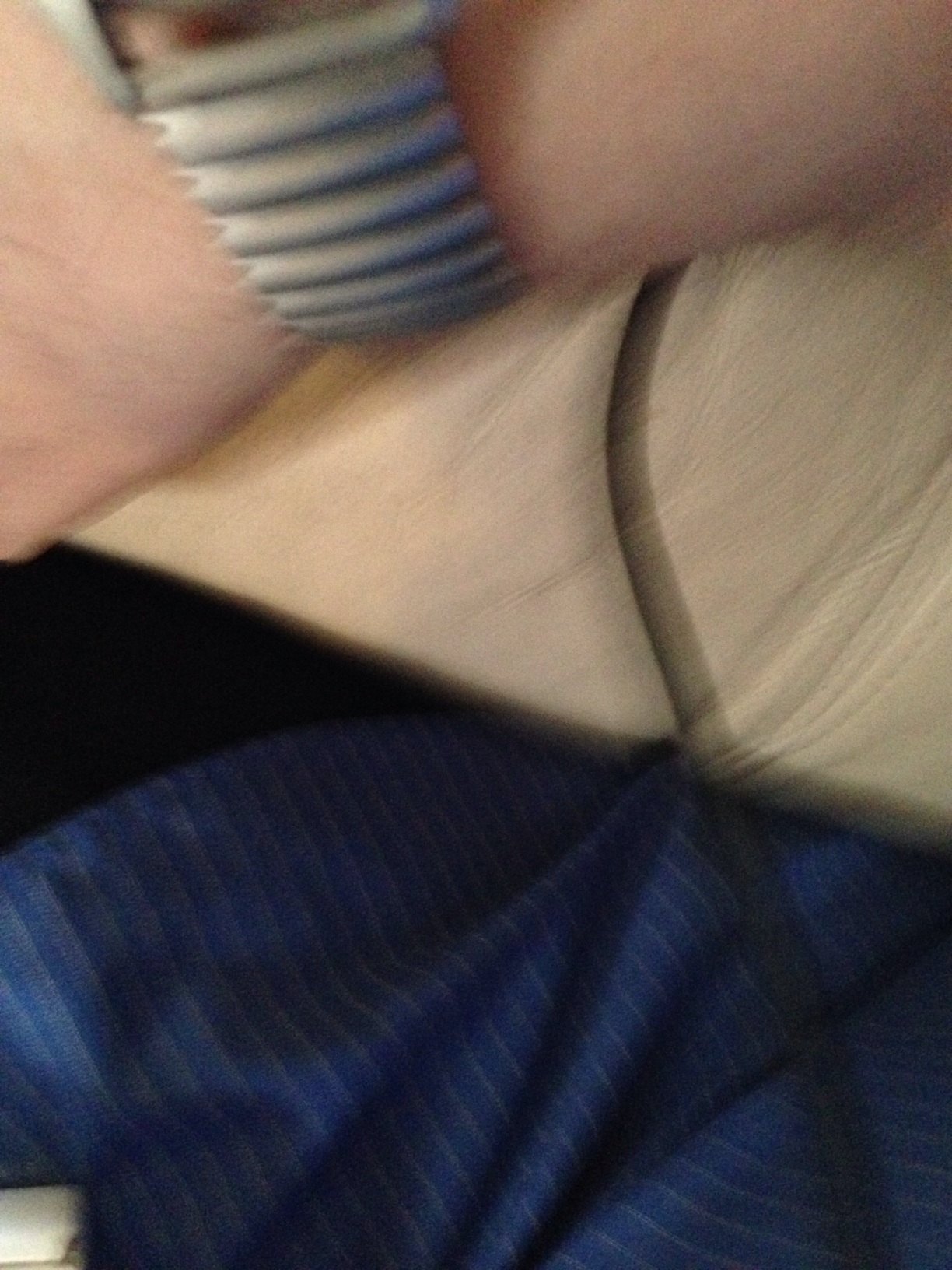 A photo captured by a person who is blind. A computer-generated caption for this photo is: A close up of a person on a bed.