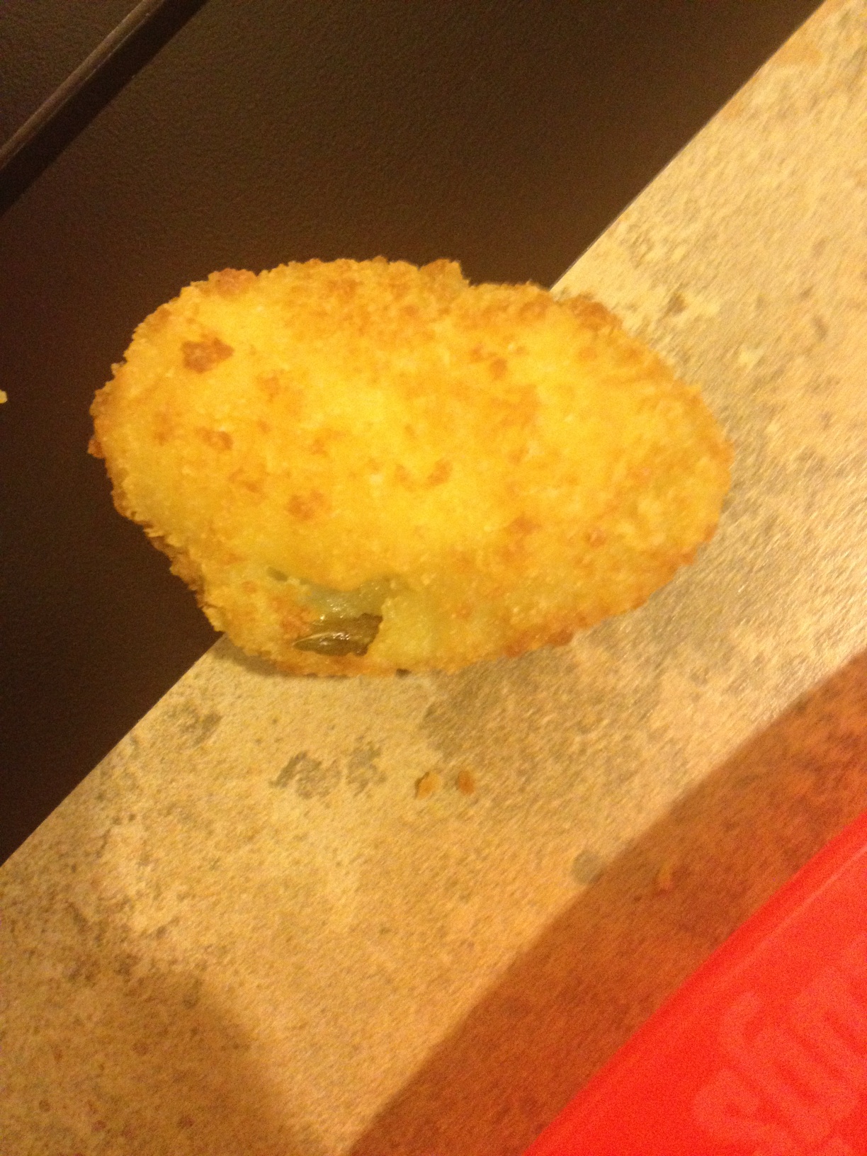 A photo captured by a person who is blind. A computer-generated caption for this photo is: A close up of a doughnut on a table.