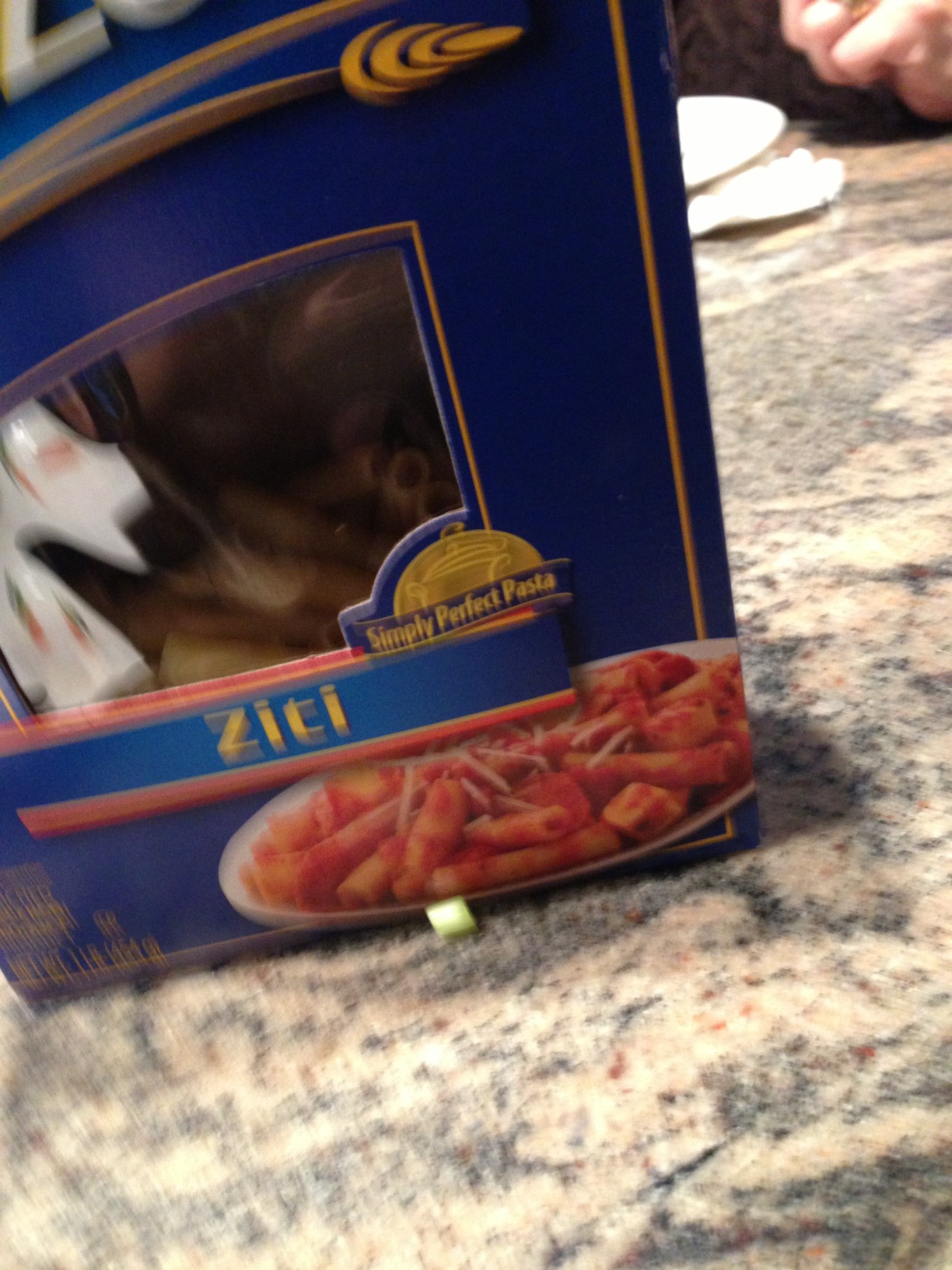 A photo captured by a person who is blind. A computer-generated caption for this photo is: A blue plate with a box of food.