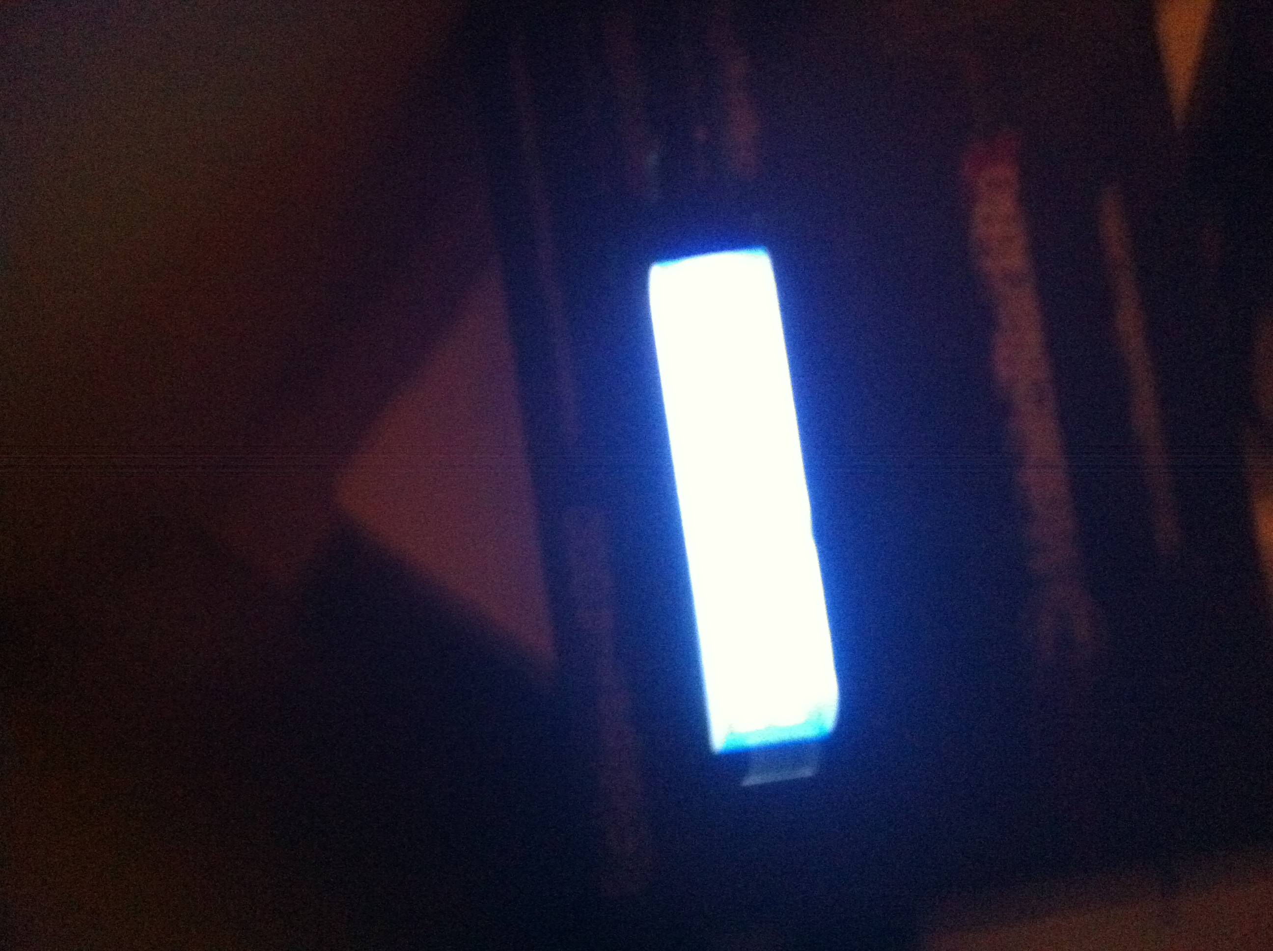 A photo captured by a person who is blind. A computer-generated caption for this photo is: A close up of a street sign in the dark.