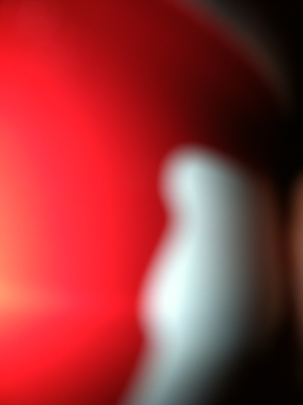 A photo captured by a person who is blind. A computer-generated caption for this photo is: A close up of a red and white apple.