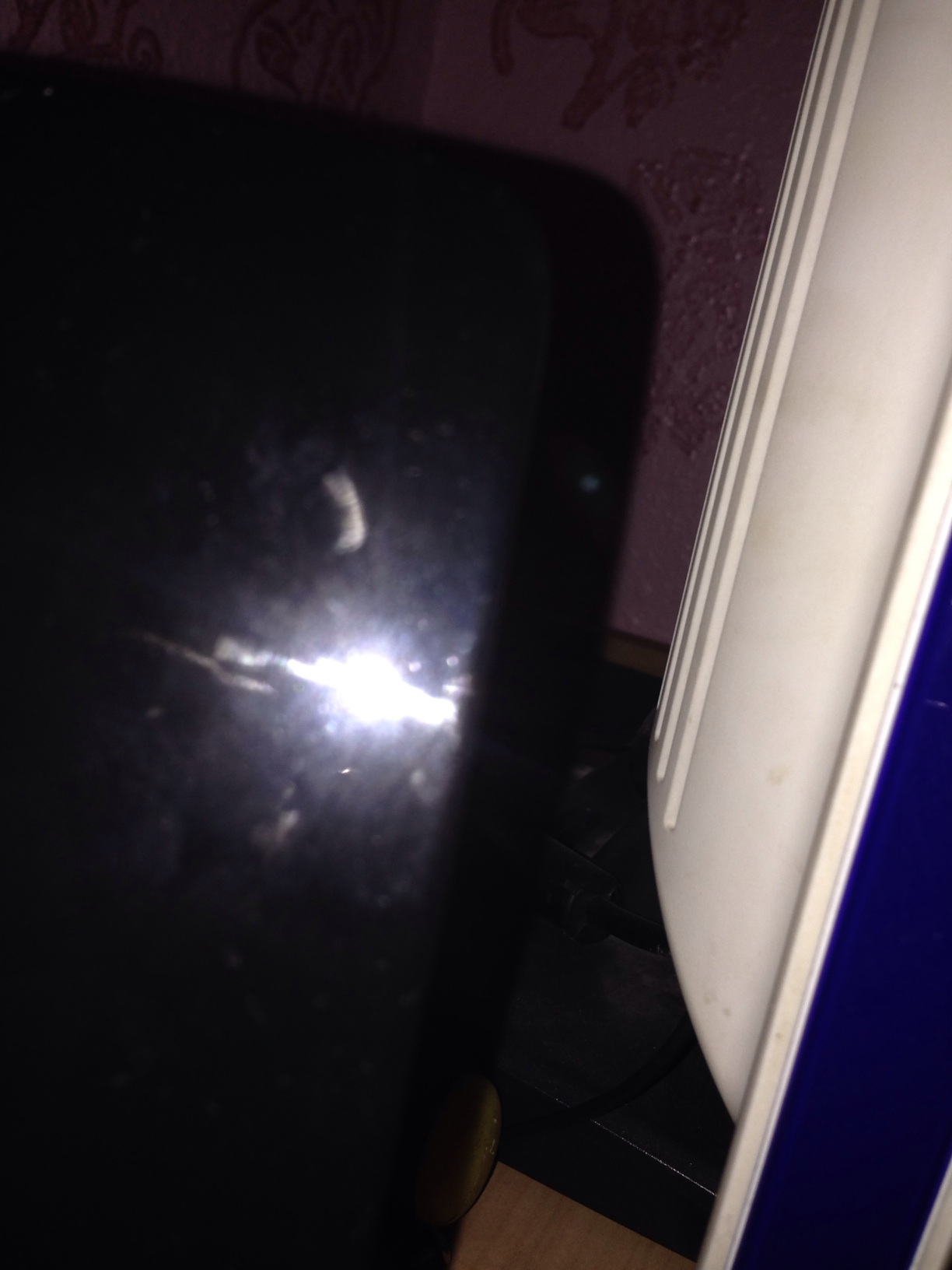 A photo captured by a person who is blind. A computer-generated caption for this photo is: A view of a window with a light in it.