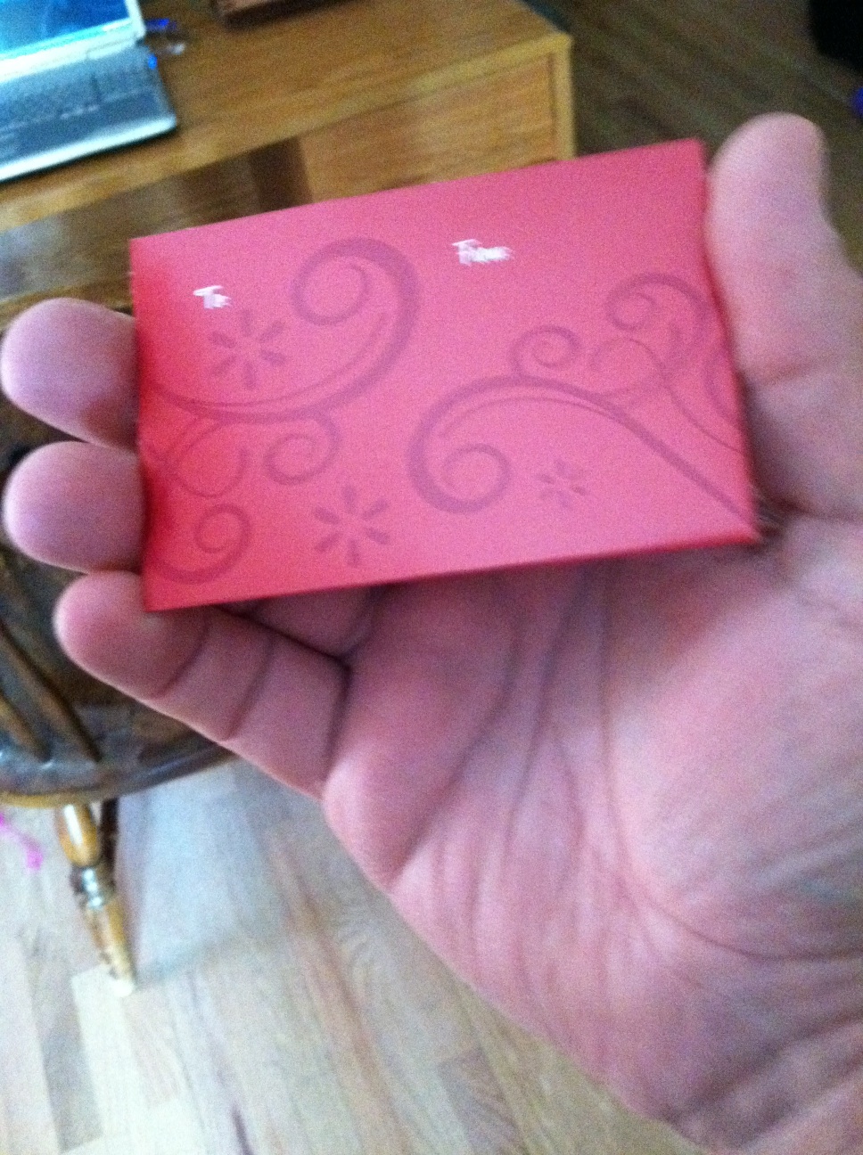 A photo captured by a person who is blind. A computer-generated caption for this photo is: A close up of a person holding a pink book.