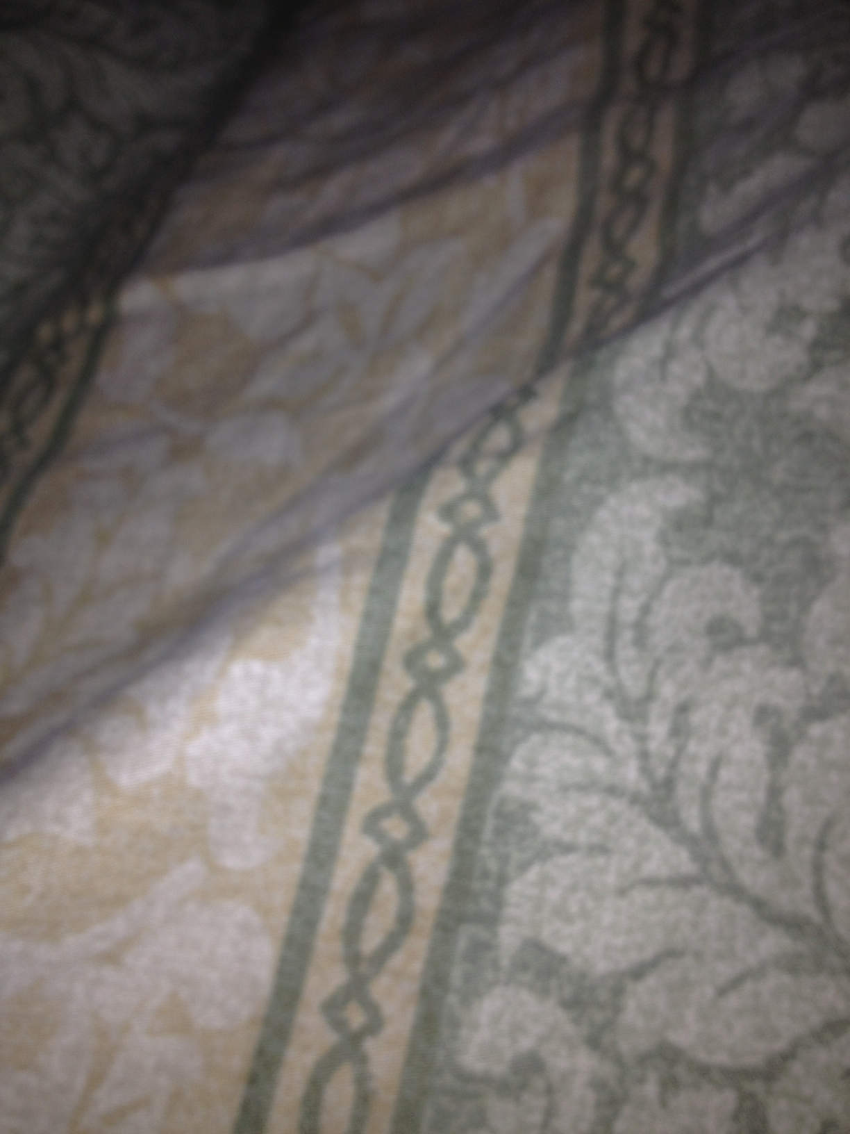 A photo captured by a person who is blind. A computer-generated caption for this photo is: A close up of a blanket on a bed.