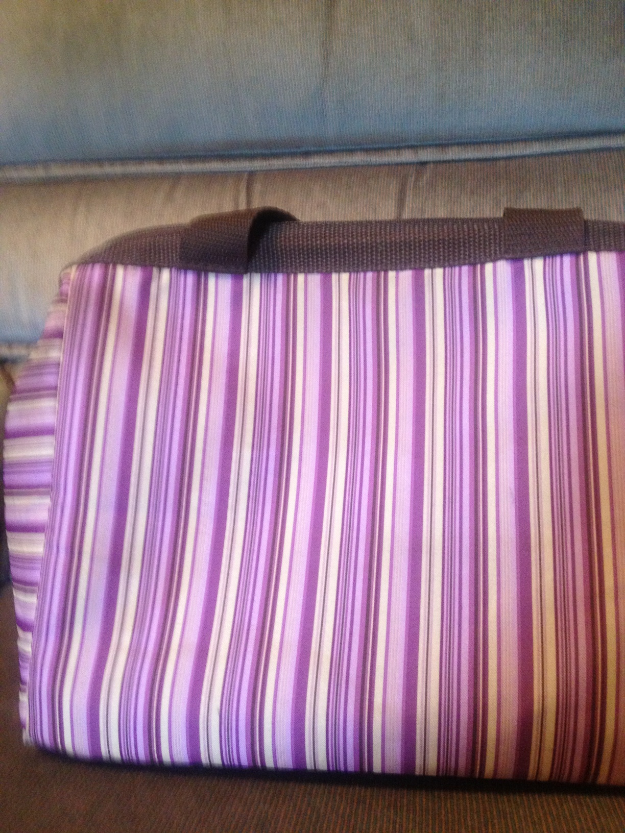 A photo captured by a person who is blind. A computer-generated caption for this photo is: A purple bed sitting on a wooden floor.