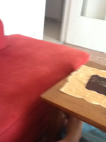 A photo captured by a person who is blind. A computer-generated caption for this photo is: A bed with a red blanket on it.
