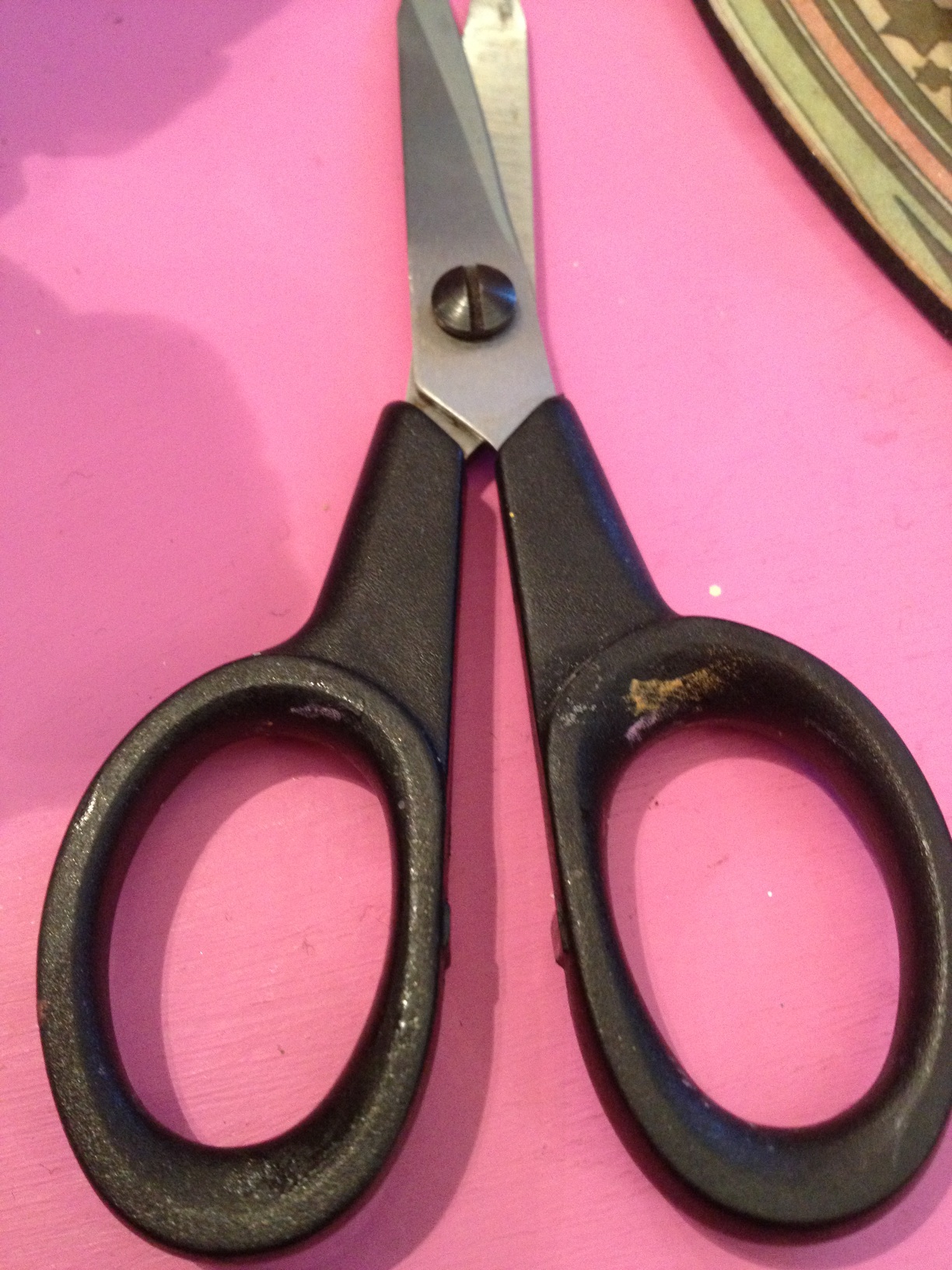 A photo captured by a person who is blind. A computer-generated caption for this photo is: A close up of a pair of scissors.