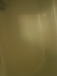 A photo captured by a person who is blind. A computer-generated caption for this photo is: A close up of a glass of a white wall.