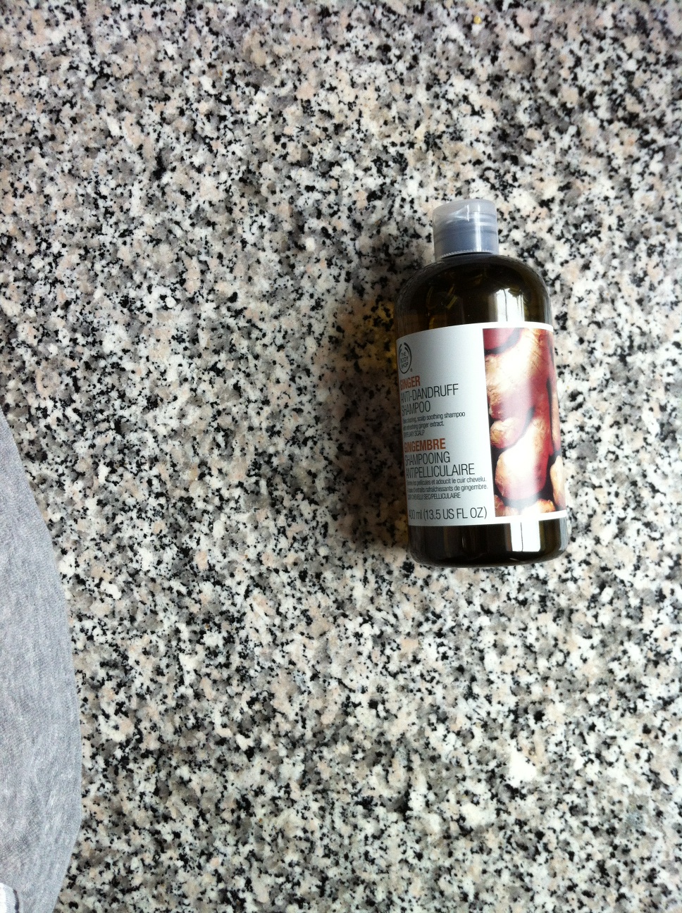 A photo captured by a person who is blind. A computer-generated caption for this photo is: A bottle of beer sitting on top of a counter.
