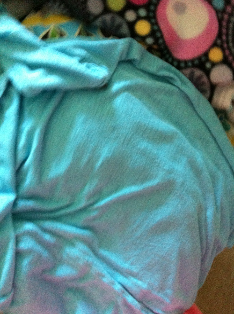 A photo captured by a person who is blind. A computer-generated caption for this photo is: A close up of a blanket on a bed.