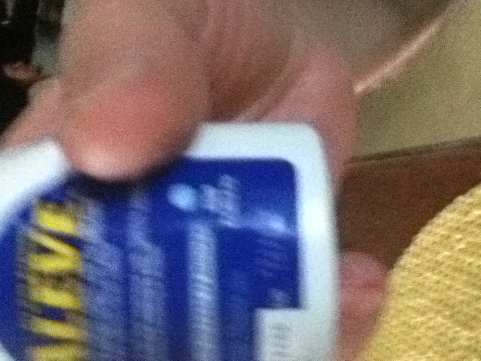 A photo captured by a person who is blind. A computer-generated caption for this photo is: A close up of a man sitting on a couch.