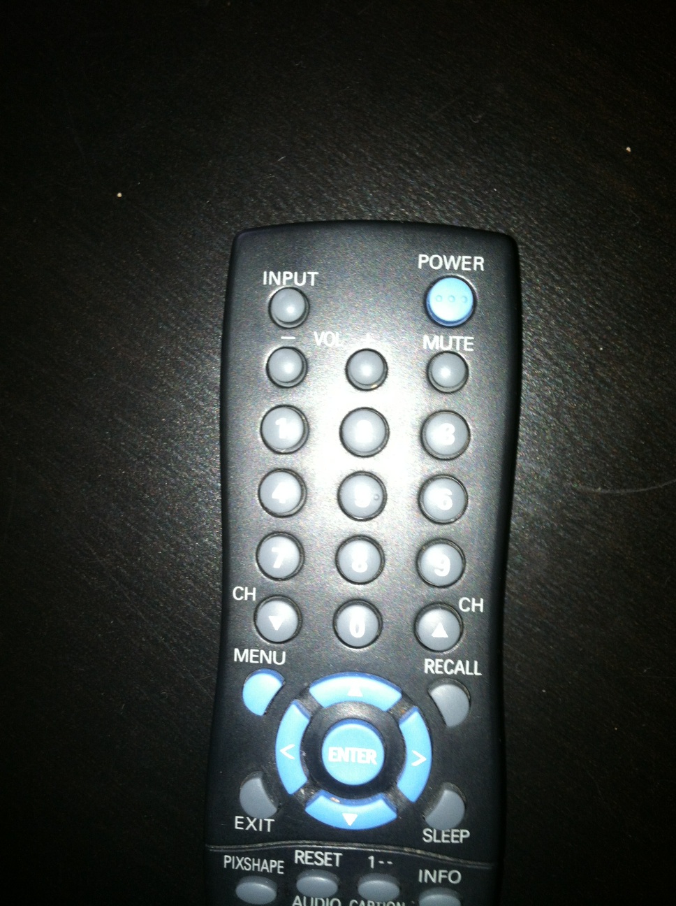 A photo captured by a person who is blind. A computer-generated caption for this photo is: A remote control sitting on a black table.