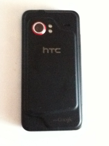 A photo captured by a person who is blind. A computer-generated caption for this photo is: A close up of a black cell phone.
