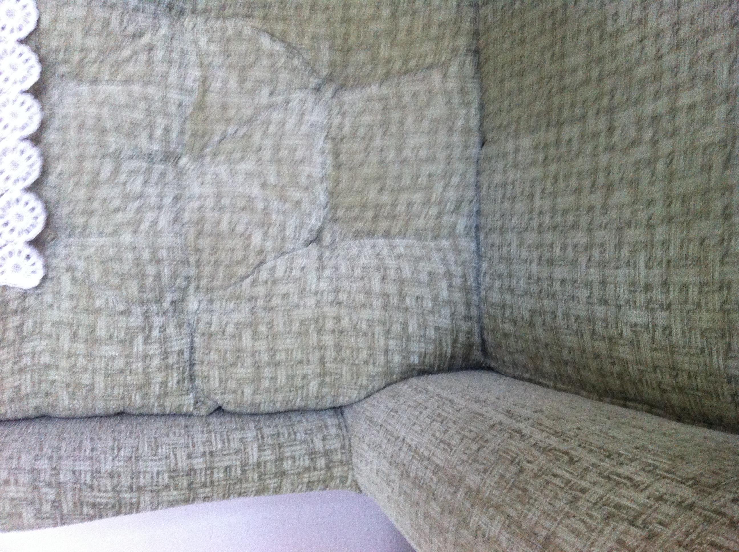 A photo captured by a person who is blind. A computer-generated caption for this photo is: A close up of a bed with a couch.