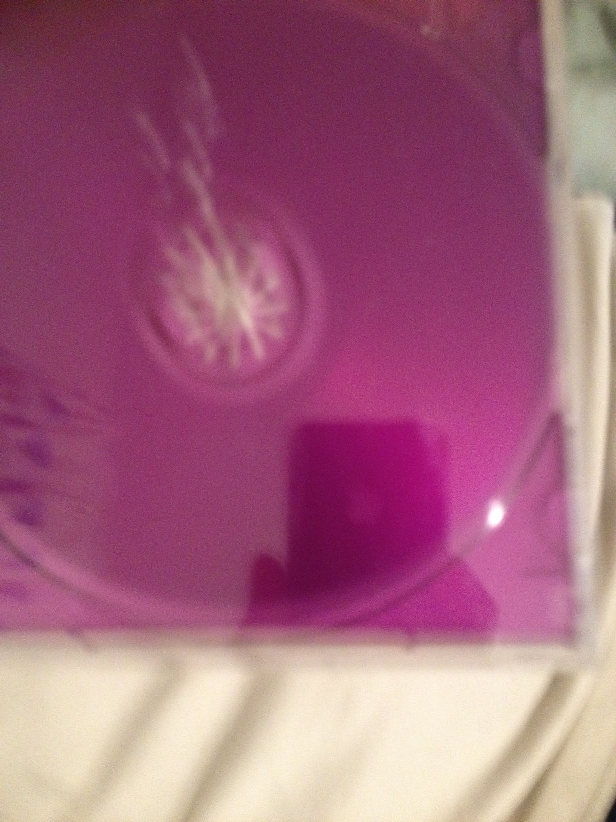 A photo captured by a person who is blind. A computer-generated caption for this photo is: A close up of a purple and white vase.