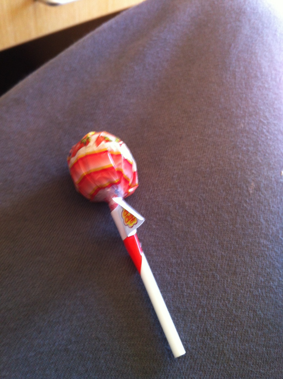 A photo captured by a person who is blind. A computer-generated caption for this photo is: A red and white toothbrush is holding a bat.
