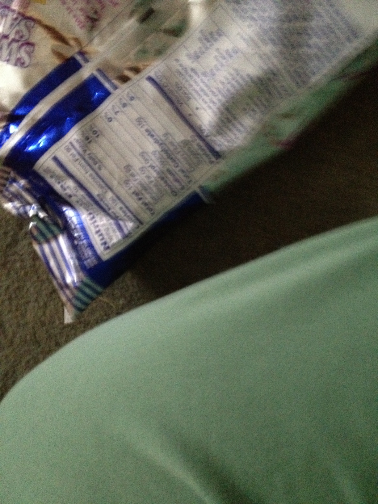 A photo captured by a person who is blind. A computer-generated caption for this photo is: A toothbrush and a bottle on a table.